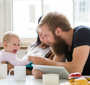 Familie mit Baby am Frühstückstisch