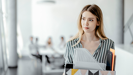 Junge Frau trägt Büromaterial 