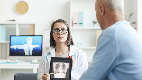 Ärztin zeigt einem Patienten sein Röntgenbild 